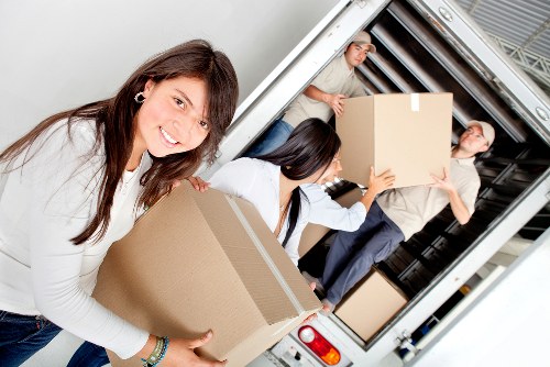 Moving team handling furniture carefully in a West London property