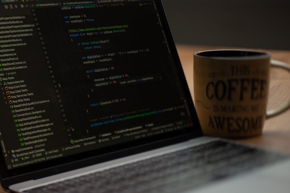 A silver laptop with a black keyboard is positioned on a wooden table inside a home, displaying lines of code or scripting on its screen. In the background, a cozy interior is visible with wooden furn